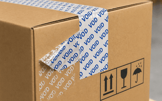 Tamper tape applied to cardboard carton on pallet, showing VOID security seal for supply chain protection by JW Products