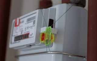  A water meter securely attached to a pipe, featuring a visible seal tag for security purposes
