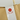 A brown paper bag featuring a prominent red tamper-proof sticker for security and authenticity.
