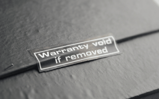  A black box displaying a sticker that reads "Warranty Voided," indicating potential returns fraud.