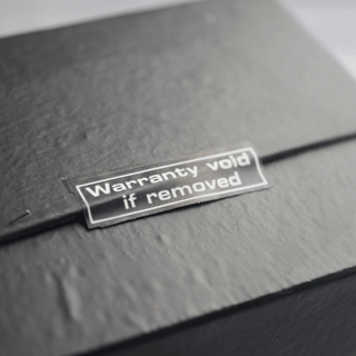  A black box displaying a sticker that reads "Warranty Voided," indicating potential returns fraud.