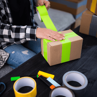 Applying tamper tape around a box, ensuring the contents remain sealed for event equipment hire.