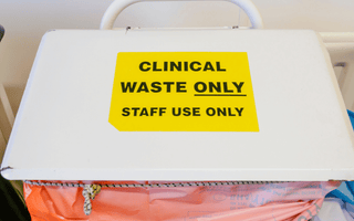 A white box displaying a sign about clinical waste sacks and their traceability with security seals.