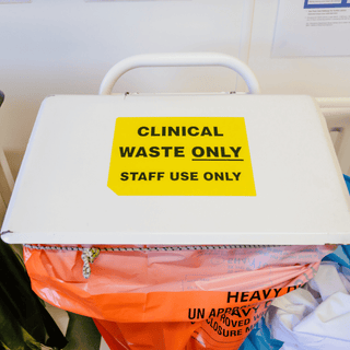 A white box displaying a sign about clinical waste sacks and their traceability with security seals.