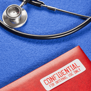 A stethoscope beside a red folder labeled "Confidential," featuring a tamper-evident seal for medical records security.