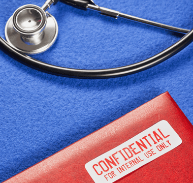 A stethoscope beside a red folder labeled "Confidential," featuring a tamper-evident seal for medical records security.