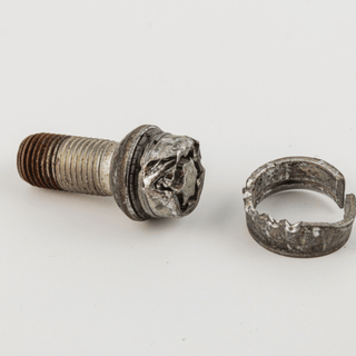 A screw and a circular ring displayed together, highlighting their metallic textures and shapes.