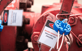 A red valve equipped with a tag, likely for identification or safety instructions.
