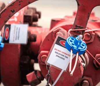 A red valve equipped with a tag, likely for identification or safety instructions.