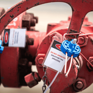 A red valve equipped with a tag, likely for identification or safety instructions.