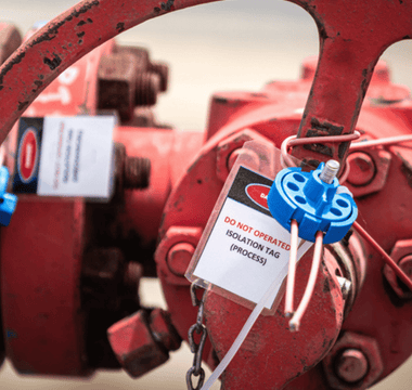 A red valve equipped with a tag, likely for identification or safety instructions.