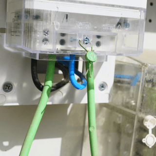 Close-up image showing a white electrical box and its green wire connections.